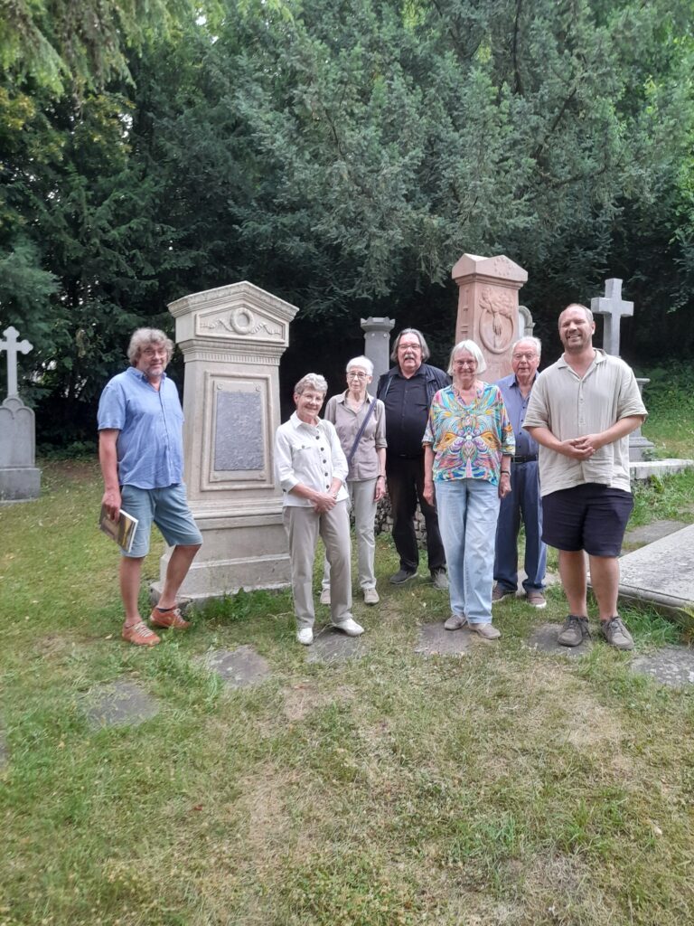 Vorstellung der Restaurierungsarbeiten vor Ort,
von links nach rechts:
Dipl. Restaurator Thomas Sieverding,
Hela Monheim (Verschönerungsverein Bergisch Gladbach e.V.),
Dr. Marion Grams-Thieme (Förderverein des ev. Friedhofs Quirlsberg),
Prof. Dr. Michael Werling (Verschönerungsverein Bergisch Gladbach e.V.),
Irmtraud Schumacher (Förderverein des ev. Friedhofs Quirlsberg),
Franz Josef Vierkotten (Vorsitzender des Verschönerungsvereins Bergisch Gladbach e.V.),
Pfarrer Tim Herzog (ev. Kirchengemeinde).
(Foto: Verschönerungsverein Bergisch Gladbach e.V., Fotograf: Lutz Urbach)